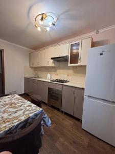 a kitchen with white cabinets and a white refrigerator at Ермекова in Karagandy
