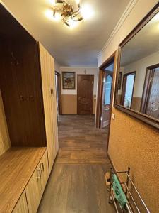 een hal van een huis met houten vloeren en een deur bij Ермекова in Karagandy