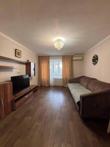 a living room with a couch and a flat screen tv at Ермекова in Karagandy