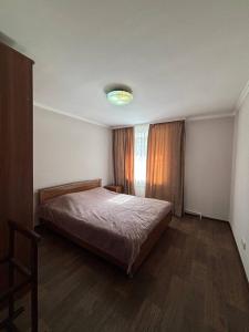 a bedroom with a large bed and a window at Ермекова in Karagandy +3 photos