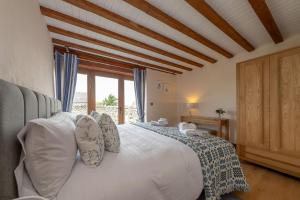 a bedroom with a bed with pillows and a window at Tyddyn-Hendre in Llanfairpwllgwyngyll