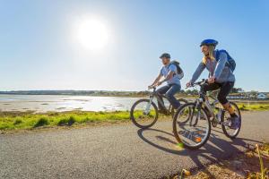 two people riding bikes down a road at Tyddyn-Hendre in Llanfairpwllgwyngyll