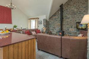 a kitchen and living room with a stone wall at Mynachdy-Sarn in Sarn
