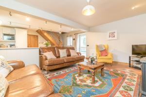 a living room with a couch and a table at Ysgubor-Sarn in Sarn