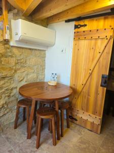 a wooden table in a room with a barn door at Moinho das Longas in Montelavar