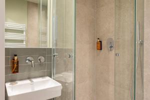 a bathroom with a sink and a shower at Hotel Columbia in Berlin +2 photos