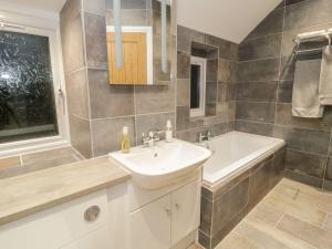 een badkamer met een wastafel en een ligbad bij Riverside Cottage in Conwy +14 foto's