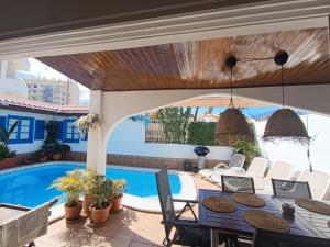 a patio with a table and chairs and a swimming pool at Beautiful Holiday Villa with heated private pool, Los Cristianos in Los Cristianos +47 photos
