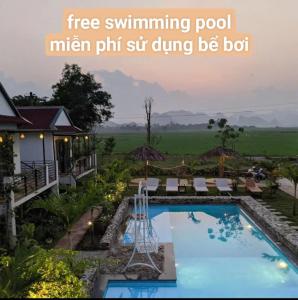 a swimming pool with atree swimming pool man pit situngjong be bat at Palafita Bungalow in Phong Nha