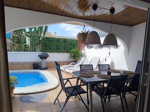 a patio with a table and chairs next to a swimming pool at Beautiful Holiday Villa with heated private pool, Los Cristianos in Los Cristianos