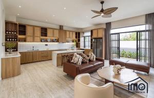 ホーチミン・シティにあるMaison Villa de Palm Marina A83 Luxのソファとテーブルのあるキッチンとリビングルーム