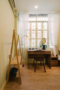 Cette chambre comprend un bureau et une table avec une chaise. dans l'établissement Anchie Home Lý Nam Đế- Ha Noi Train Street- Ha Noi Old Quarter, à Hanoï
