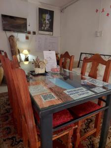 a dining room table with chairs and a table with certificates at La Casa de La Linda in Salta