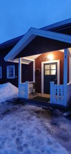 ein Haus mit einer Veranda mit Schnee auf dem Boden in der Unterkunft Aurora Cottage Åre Järpen 