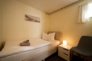 a small room with a bed and a chair at Haus Sonnenwinkel Bungalow 3 in Dahme +11 photos