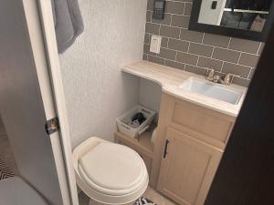 ein kleines Badezimmer mit Toilette und Waschbecken in der Unterkunft DDs Country Camper in Reedley + 8 Fotos