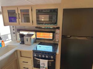 eine Küche mit Herd und Mikrowelle in der Unterkunft DDs Country Camper in Reedley