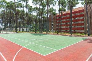 una pista de tenis frente a un edificio en AluaSun Marbella Park en Marbella