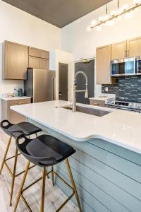 a kitchen with a counter and two bar stools at Boutique 1BR Condo - Walk to Memorial Stadium - Historic Hayward Place in Lincoln
