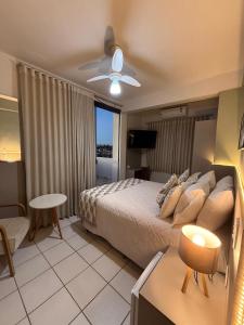 une chambre avec un lit et un ventilateur de plafond dans l'établissement Hotel Ze Maria Cambui, à Cambuí