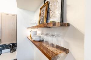 a shelf with glasses on a wall in a bathroom at Boutique 1BR Condo - Walk to Memorial Stadium - Historic Hayward Place in Lincoln +43 photos