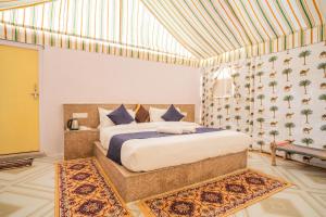 a bedroom with a king sized bed in a room at Sand Routes Resort & Desert Camp in Sām +17 photos