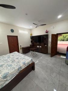a bedroom with a bed and a flat screen tv at Jeyaraj's Guest House in Samayanallūr