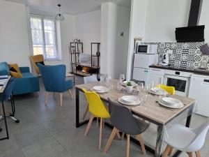 a dining room and living room with a table and chairs at L'Adeline Escapade de Charme et Calme proche Guédelon in Bléneau