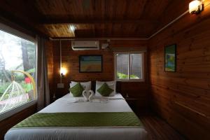 a bedroom with a bed in a wooden cabin at Adhvasaha Beach Spa Resort in Port Blair +86 photos