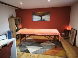 une chambre avec une table et un arbre sur le mur dans l'établissement Gîte du Feuil, à Blassac