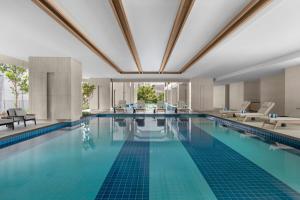 a large swimming pool with blue tiles in a building at Marriott Executive Apartments Kuala Lumpur in Kuala Lumpur