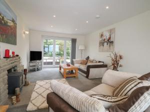 a living room with two couches and a television at Walmer Court Farmhouse in Great Mongeham