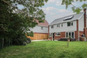 a house with a wooden fence and a yard at Walmer Court Farmhouse in Great Mongeham