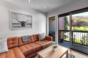 een woonkamer met een bruine leren bank en een tafel bij Snowcrest 216 condo in Park City