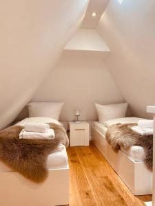 a attic bedroom with two beds with fur at Ocean-View-II-Holiday-Apartments-Sylt in Rantum