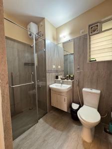 Un baño con inodoro, ducha y lavabo. en Luxury 2BhK by Cocopalm BnB, 