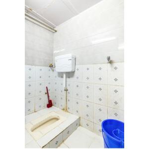La salle de bains est pourvue d'un lavabo et d'un mur carrelé blanc. dans l'établissement goldenstar deluxe dormitory, à Mumbai