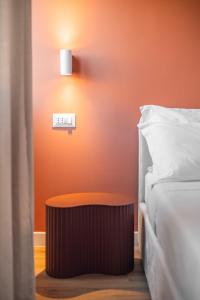 a clock on a wall next to a bed at Carducci Collection in Bologna