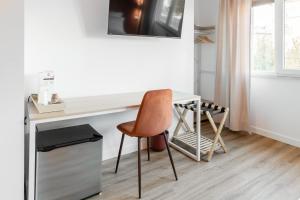 a desk with a chair next to a table at Carducci Collection in Bologna