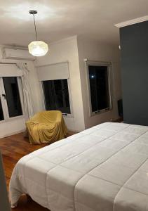 a bedroom with a large white bed and windows at Alquiler en Lobos, Empalme in Empalme Lobos +22 photos