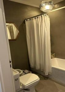 a bathroom with a toilet and a shower curtain at Alquiler en Lobos, Empalme in Empalme Lobos
