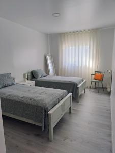 CarvideCasa da Avó Julia的有两张床和一把椅子的卧室 更多19张照片