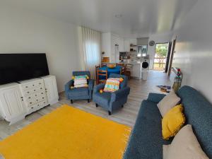 CarvideCasa da Avó Julia的带沙发、椅子和电视的客厅