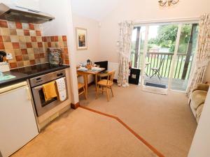 Il comprend une cuisine et un salon avec une table et une cuisinière. dans l'établissement Hayloft, à Henley