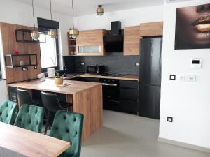 a kitchen with a table and a black refrigerator at Modern villa with charm in Trnovec near Varaždin in Trnovec