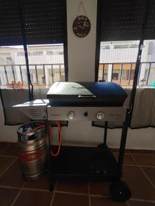 a table with a grill in a room with two windows at Casona El Chaparral in Fondón