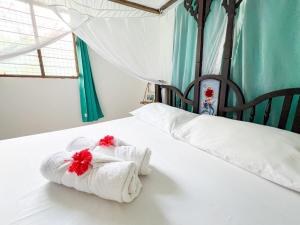 a bedroom with a bed with towels on it at Hammock Under Milky Way 5 Min To Beach & The Rock in Pingwe