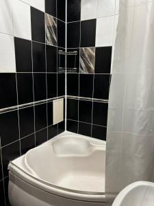 DobrovelychkivkaにあるНайкраща Квартираの黒と白のタイル張りの壁、トイレ付きのバスルーム
