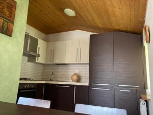 a kitchen with white cabinets and a wooden ceiling at Appartamenti Elda Zandegiacomo in Auronzo di Cadore +1 photo