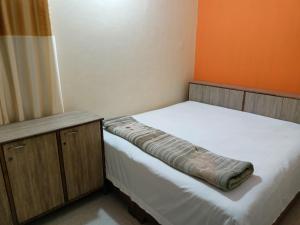 JāmbにあるShree DashbhujaNath Staysの小さなベッドルーム(ベッド1台、木製キャビネット付)